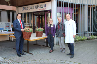 Blumenspende mit Führungskräften des OK